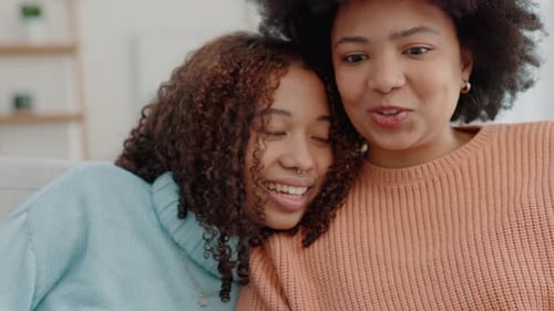 Women Chatting and Smiling on Sofa Indoors