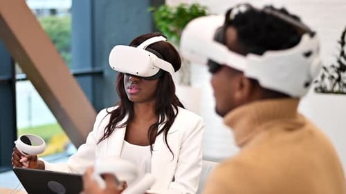Business conference in VR in an office. A black man and woman using VR glasses and controllers