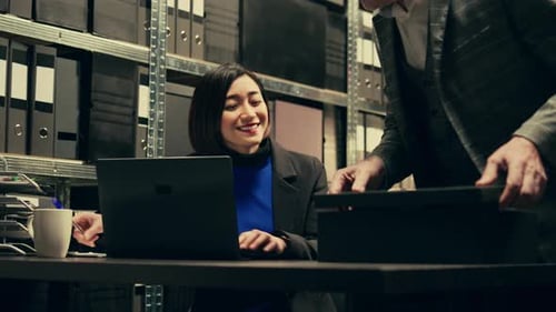 Office Workers Reviewing Documents in Warehouse Office