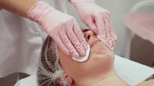 Woman Patient Relaxing in Cosmetology Clinic Beautician Gently Cleansing Skin Doctor Performing