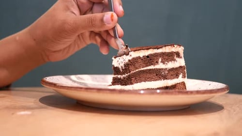 Fork Takes Bite of Chocolate Layer Cake