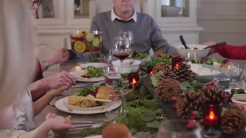 Extended family sharing christmas gratitude prayers before dinner in Canada