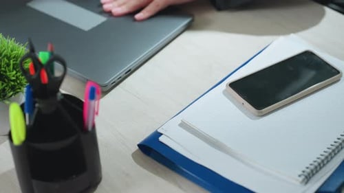 Close Up of Worker Adjusting Laptop After Dropping Folder and Phone on Desk
