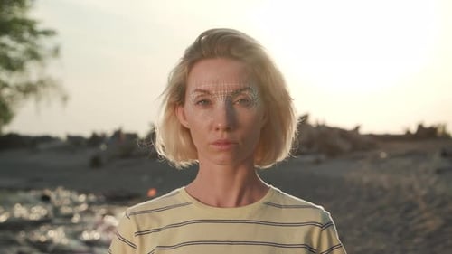 Young woman in city using facial recognition technology for secure access