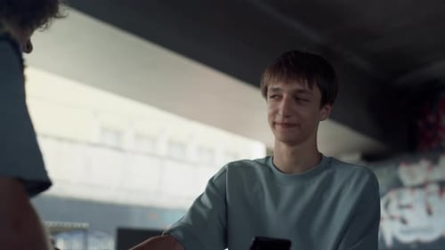 Teenage friends enjoying social media and sports on smartphones at the skatepark