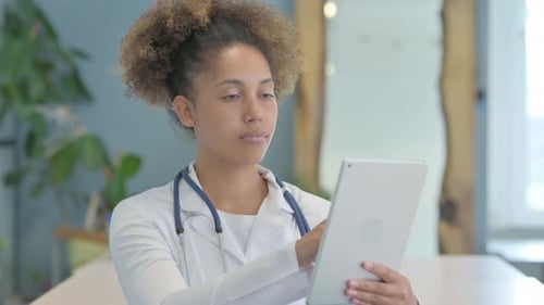 Female African Doctor using Tablet in Clinic