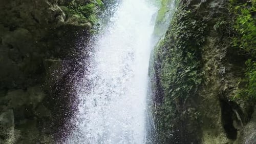 Magical mountain waterfall, crystal water, large stones overgrown with moss. The waterfall with the