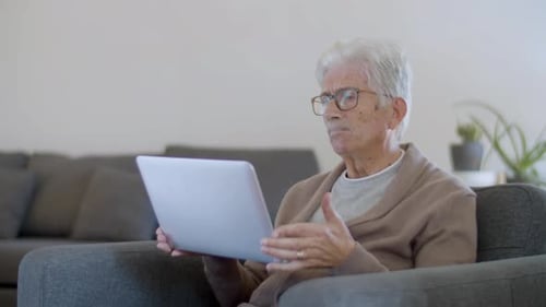 Senior Man Using Laptop in Living Room