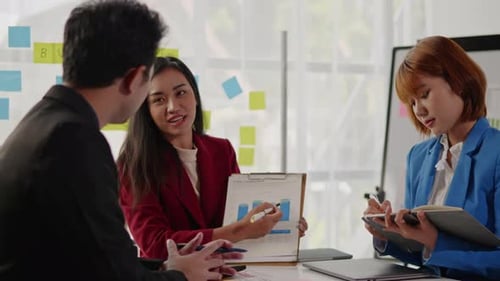 Business Team Analyzes Data Charts at Workplace