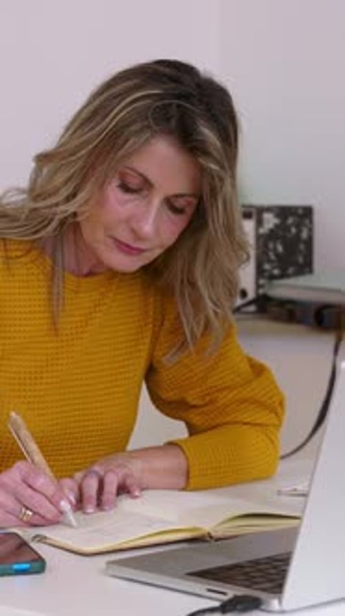 Businesswoman Working From Home Office Taking Notes and Using Laptop