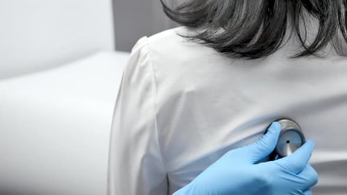 Doctor Listens to Patient's Back with Stethoscope