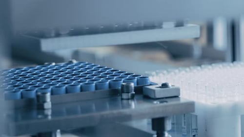 Images rapprochées de la fabrication industrielle de tubes à essai médicaux, avec des bouchons de fermeture placés sur les tubes. Ste