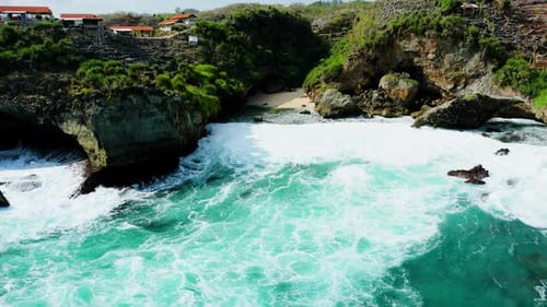 Drone flying through beautiful beach wave crashing to the shore