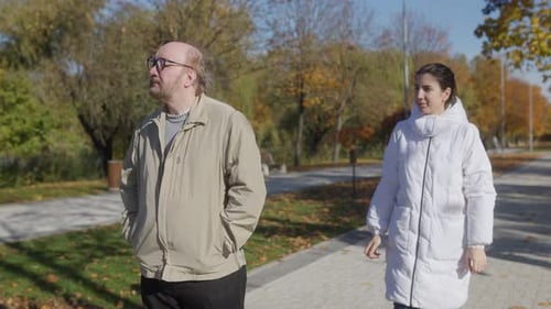 Elderly Man with Assistant Walking in Autumn Park Peaceful Scene