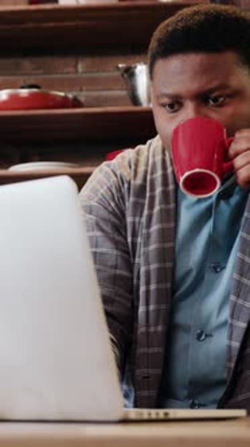 A Focused Individual is Engaged in Working on a Laptop Situated in a Cozy and Inviting Setting