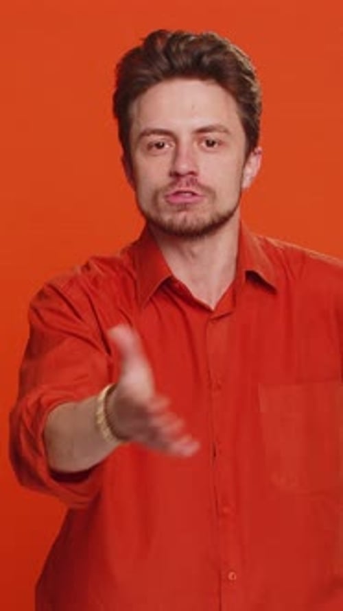 Man Gesturing and Talking on Orange Background