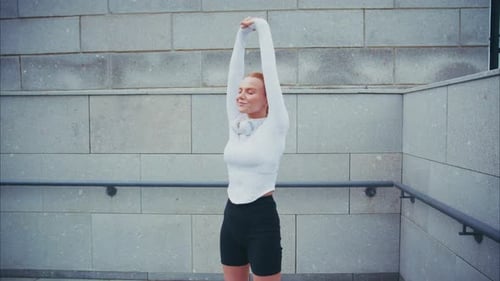 Young Woman Stretching Outdoors in Urban Setting