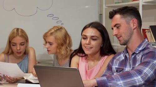 Four Young Adults Collaborating on Project With Laptop