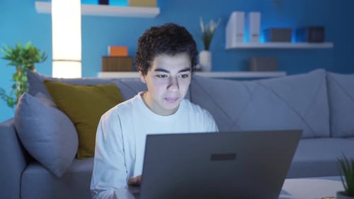 Teen Using Laptop in Home at Night