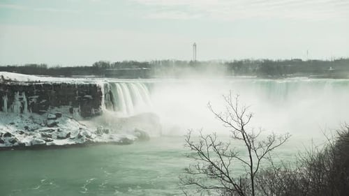 Wintertime Niagara Falls and icy surrounding cliffs, wide static view