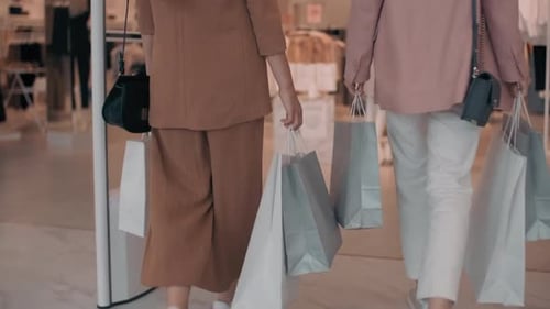 Women Walking into Clothing Store (Faces Not Visible)