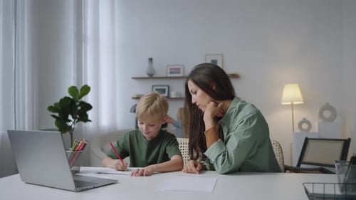 Woman Helping a Child with Homework at Home