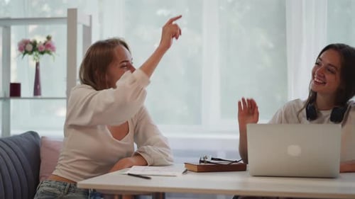 Laughing Students Give High Five Continuing Working on Task