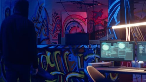 Hacker Arriving in Underground Base Looking at Spray Cans