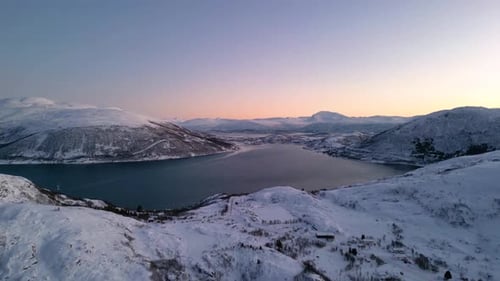 Aerial tour of Norwegian fjords at sunset with snowy mountains and blue sea in Ersfjordvegen