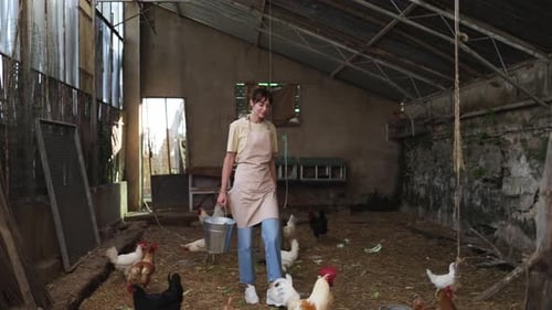 Farmer Feeding Chickens in a Barn
