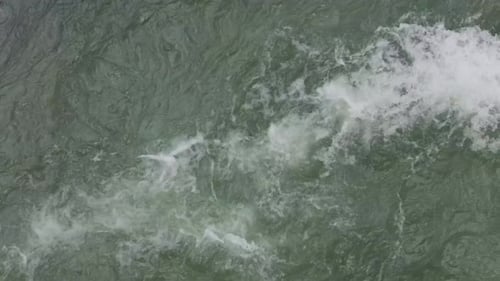 De
l'eau verdâtre tourbillonnant dans une rivière profonde. Prise de vue en grand angle.