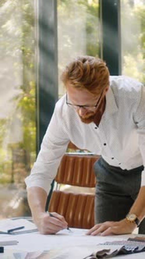 Designer Making Adjustments in Layouts in Fashionable Studio