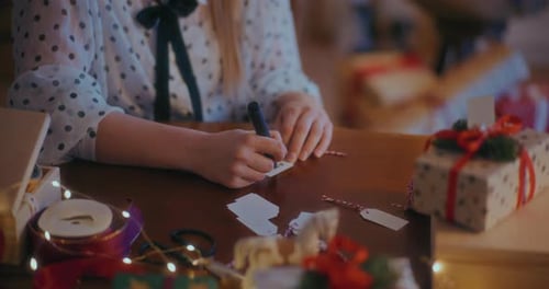Close Up Of Hands Writing Christmas Tag