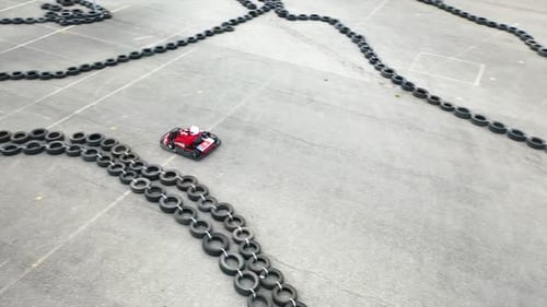 Rotes Go-Kart-Rennen auf einer von Reifen markierten Outdoor-Strecke