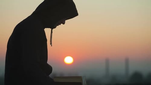 Man Reads at Sunrise, Silhouette with Book