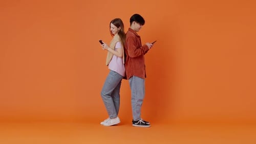 Femme et homme asiatique discutant en ligne sur smartphone en studio