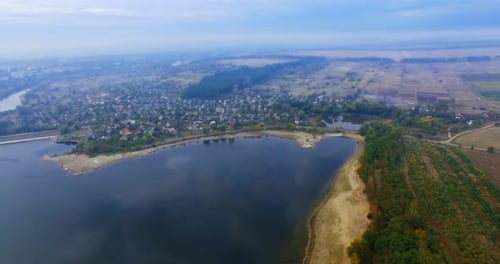Atemberaubende Landschaft des Flusses mit Dorf direkt am Wasser. Dunstiger Horizont im Hintergrund
.