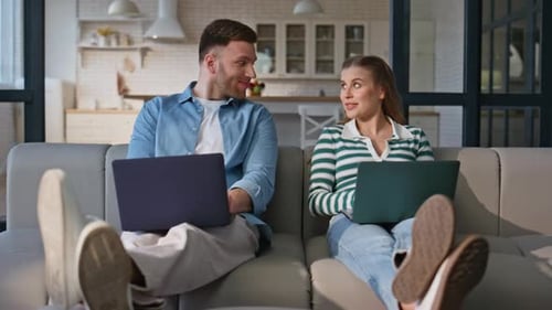 Young Couple Working Together on Laptops at Home