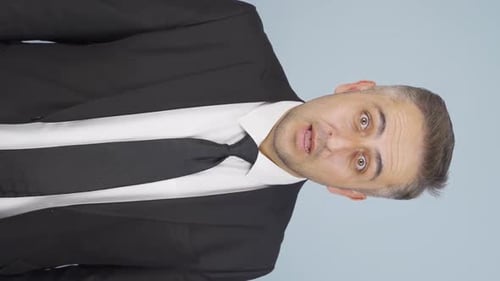 Man in Suit Speaking to Camera