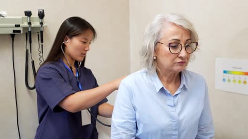 Doctor Listens to Senior Woman with Stethoscope