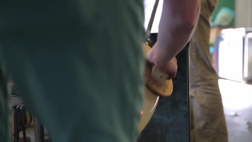 Glass artist shaping molten glass into vase