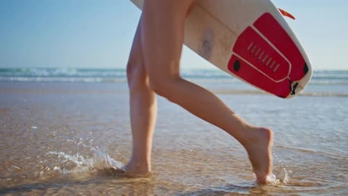 Surf Girl Legs Stepping Water at Oceanside Nahaufnahme Sportlerin betritt Meer