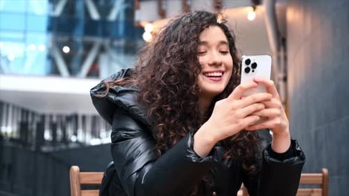 Smiling Woman Using Smartphone Outdoors in City