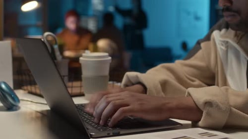 Adult Typing on Laptop in Office at Night