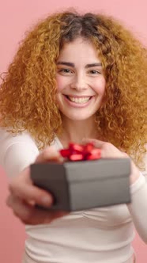Excited Woman Offers Gift to Camera