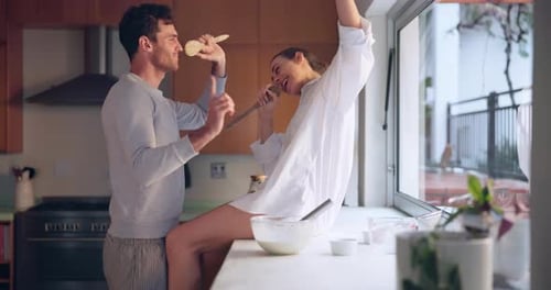 Young Couple Dancing and Singing in Kitchen