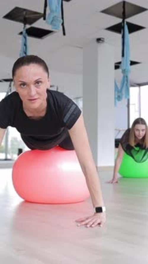 Women Using Exercise Ball in Gym for Workout