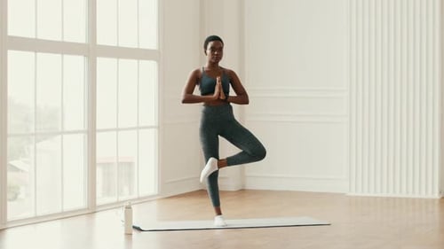 Woman Doing Tree Pose in Bright Studio