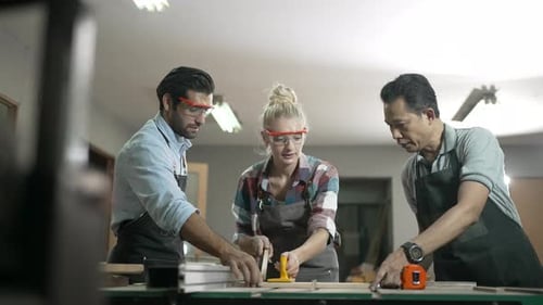 Carpenters are working together at workshop.