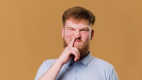 A Hilarious Studio Shot of a Young Redhead Guy Looking at Camera